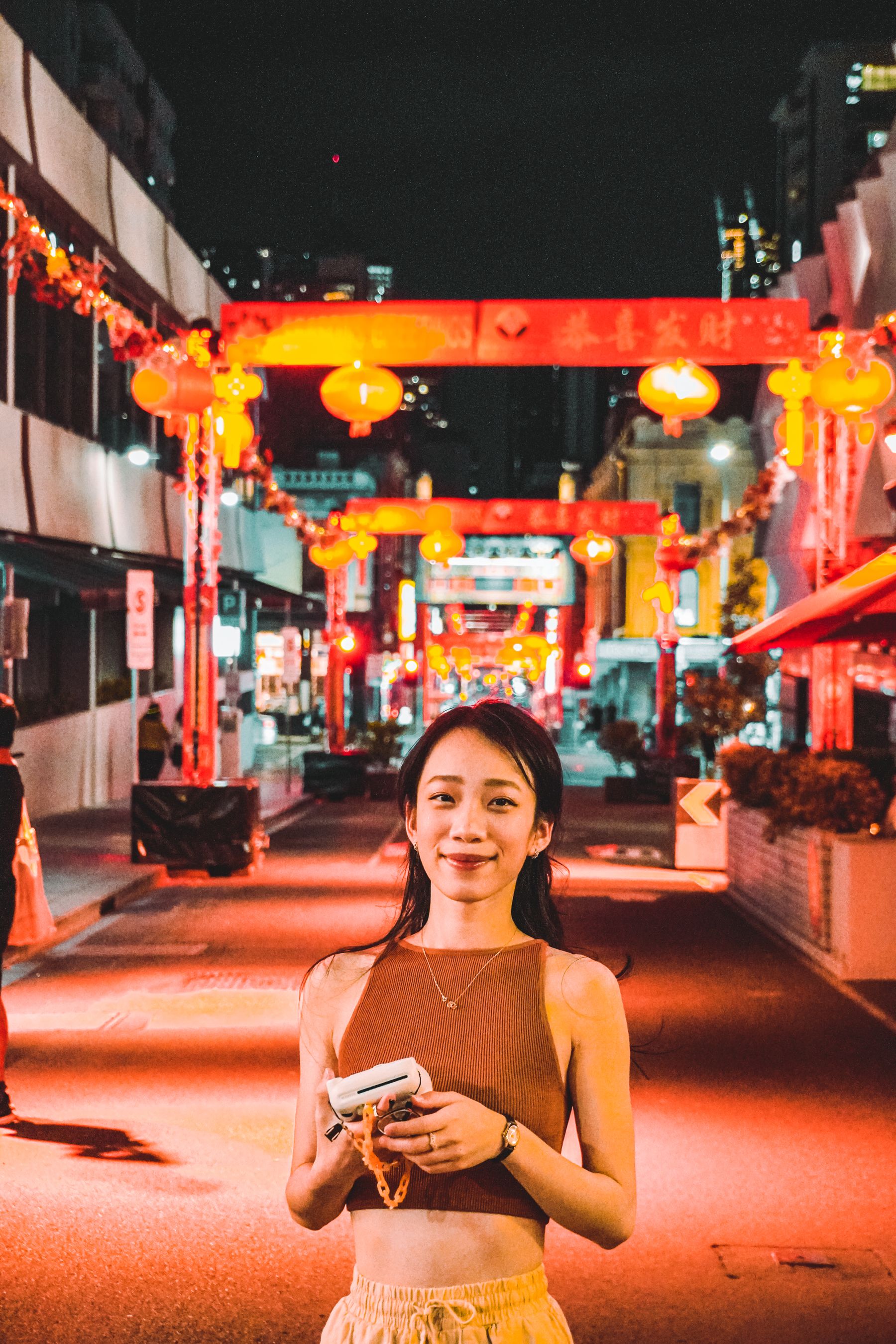 International traveler using a phone in a Chinese lantern street